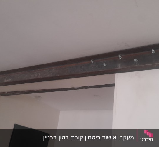 קורת פלדה מחוברת לתקרה עם ברגים